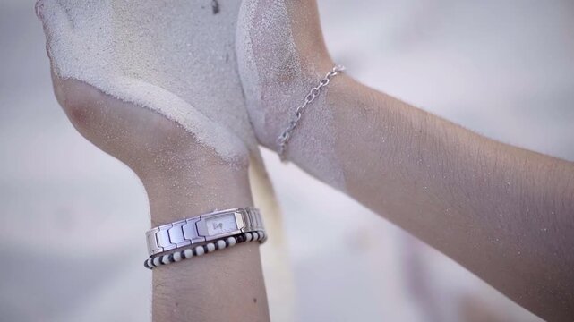 Mano dejando caer arena, reloj de area, Closeup