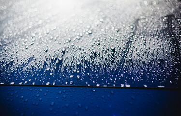 morning dew on grey car hood with water droplets close-up