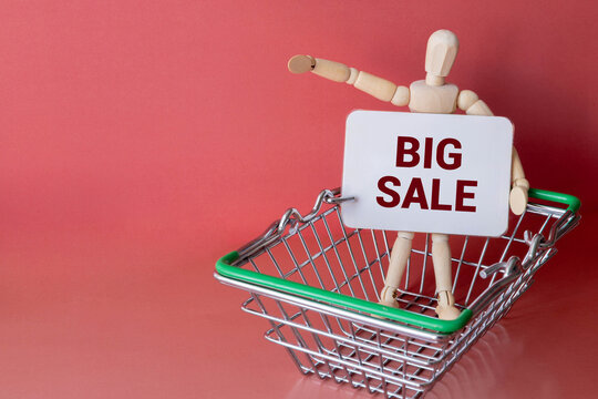 Shopping cart and wooden blocks with ''big sale'' written on white background. - Powered by Adobe