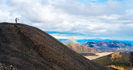 Iceland travel - Senior man admiring the view of Landmannalaugar Fjallabak Nature Reserve Central Iceland from the top of a mountain in summer