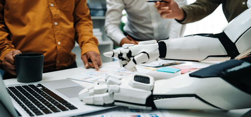 A sophisticated robot arm assists a diverse group of professionals during a collaborative meeting,...