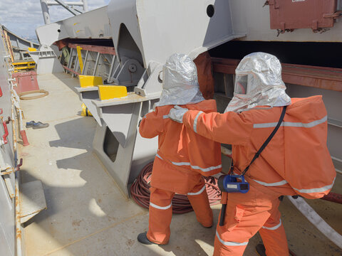 Fire Drill on Cargo Ship Crew Using Firefighting Gear, Breathing Apparatus and Hose During Emergency Training preparation to entry 1713