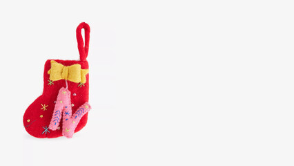 Small red decorative stocking with yellow bow and pink ornament for holiday celebrations.