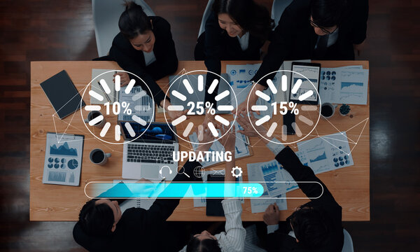 Business team engages in data analysis and updates around a conference table, enhancing collaboration with visual statistics and technology in a modern office environment. Trope