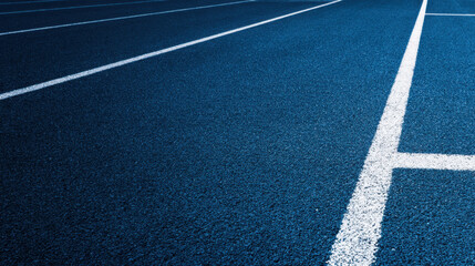 Blue running track with white lane lines leading into distance conveying motion and focus on athletic training and competition