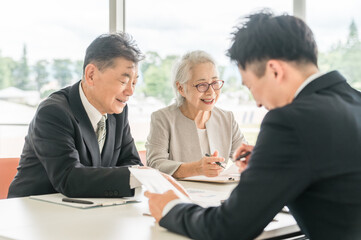 An elderly couple reviewing the proposed documents (asset management, consultation, investment, inheritance)
