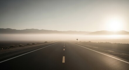 A Misty Morning Road Leading Towards The Distant Mountains And Radiant Sunlight