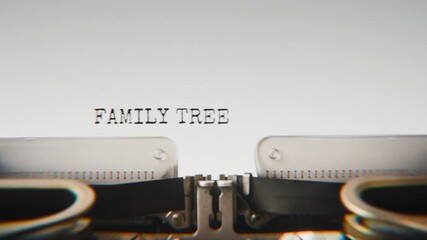 Old mechanical typewriter typing Family Tree in a close-up view, with metal letters striking the white paper.