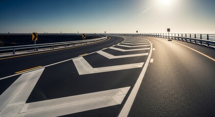 A Winding Road with Directional Markings Under A Clear Blue Sky