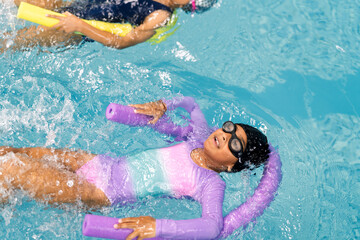 Girl learning floating technique during swimming lesson