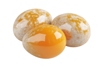 Three shiny eggs with speckled white and solid orange surfaces resting together