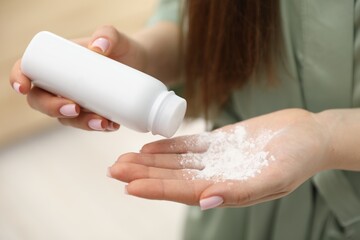 Woman using talcum powder as dry shampoo at home, closeup