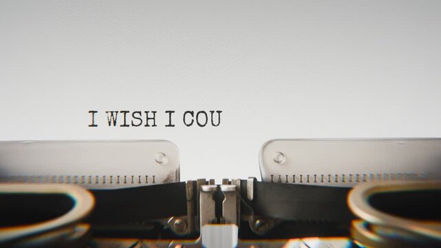 Old mechanical typewriter typing I Wish I Could Turn Back Time in a close-up view, with metal letters striking the white paper.