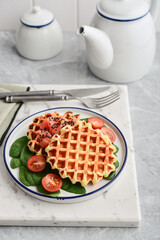 Homemade waffles with lightly salted salmon, spinach and cherry tomatoes