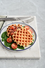 Homemade waffles with lightly salted salmon, spinach and cherry tomatoes