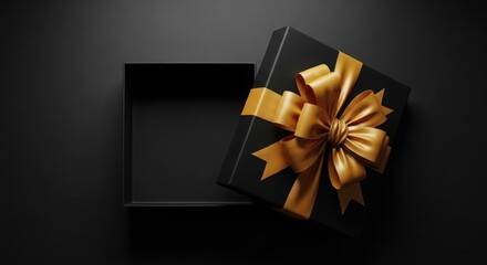 Elegant black gift box with golden ribbon bow on dark background