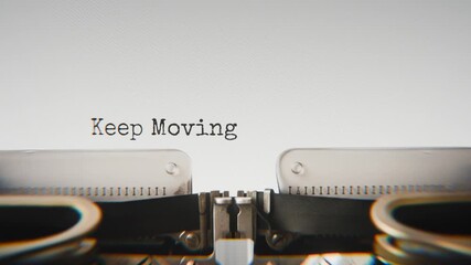 Old mechanical typewriter typing Keep Moving Forward in a close-up view, with metal letters striking the white paper.