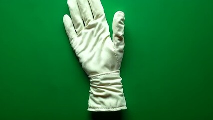 White glove on green background for cleaning tasks