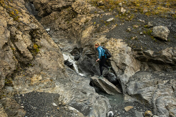 Woman Crosses Small Water Fall Along The Eiger Trail