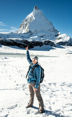 Woman Standing In Snow And Pointing At The Matterhorn