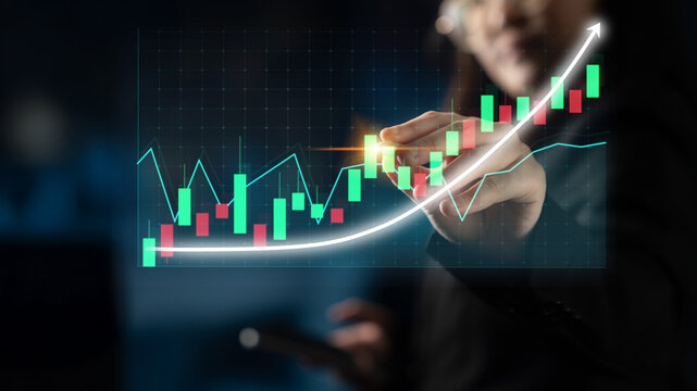 A business professional engages with a digital financial graph in a modern office, illustrating growth trends and market analysis for informed decision-making. Impute