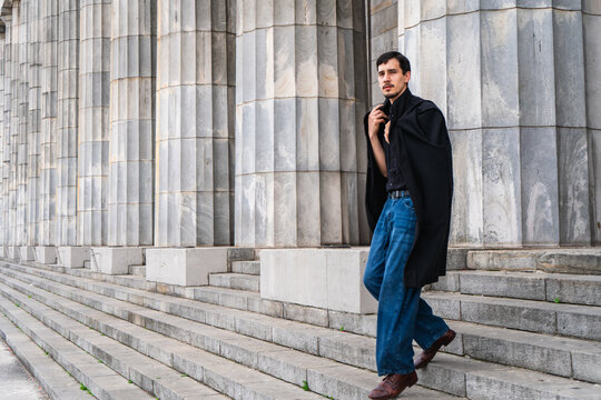 Man in academic gown walking down college stairs