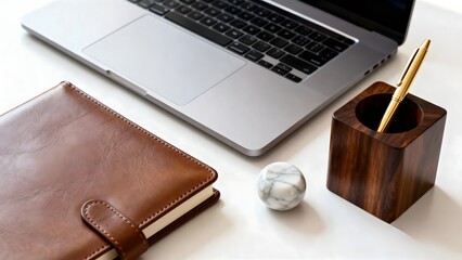 Modern office workspace with laptop, notebook and pen holder on white desk
