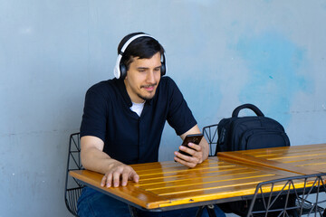 Young man listening music using smartphone headphones