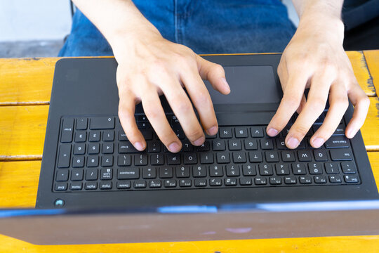 Person's hands typing on laptop keyboard