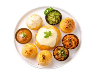 A variety of Indian snacks and appetizers arranged on a white plate with garnishes and dips