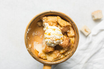 Overhead view of homemade bread pudding with vanilla ice cream, top view of fresh bread pudding with cream