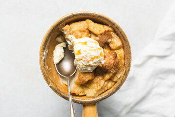 Overhead view of homemade bread pudding with vanilla ice cream, top view of fresh bread pudding with cream