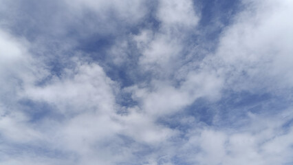 Soft blue sky with scattered white clouds and soft light creating calm atmosphere