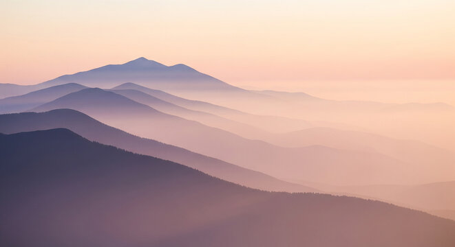 A serene and beautiful landscape of rolling mountains layered in mist at sunrise, a perfect peaceful and atmospheric image for nature and travel