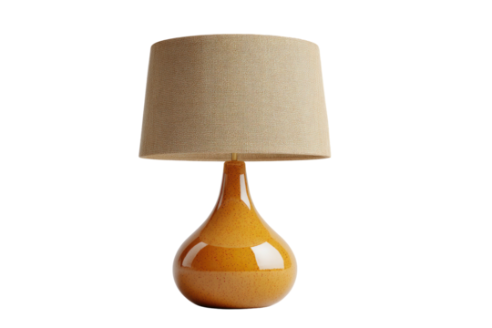 Lit tan lamp with shapely base and a drum shade, isolated