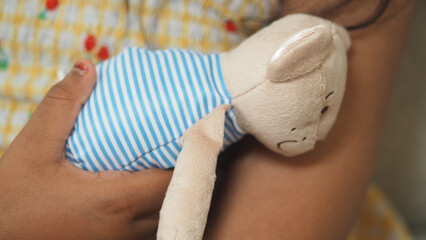 Soft toy hugs child in cozy setting during afternoon