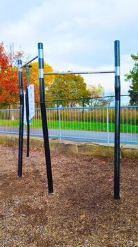 Outdoor fitness park with parallel bars for strength training offers a vibrant autumn backdrop, perfect for active lifestyles and promoting health and wellness in scenic locations