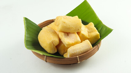Cassava Tape on a rattan plate with a banana leaf base on a white background, a traditional Indonesian food, made from cassava with yeast fermentation
