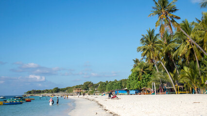 tropical beach with coconut palm trees and blue sky at Bara beach, Bira Bay