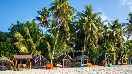 tropical beach with coconut palm trees and blue sky at Bara beach, Bira Bay