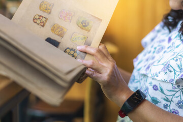 Close up to woman finger with menu choosing dishes at restaurant. A person reading menu at table. Woman with menu in restaurant making order. People select order from menu. Order food through menu.