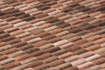 Rustic old roof with clay terracotta tile creating warm texture and pattern. great background for architecture and building concepts. close up view of overlapping rows