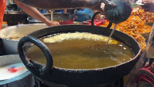 Fresh jalebis being fried in a neighbourhood shop on the streets of Kolkata in wintertime.