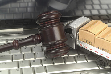 Truck model with many carton boxes and judge gavel on laptop computer close up. Legal regulation of...
