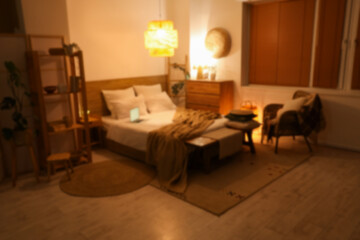 Bedroom with laptop on comfortable bed and glowing lamps at night
