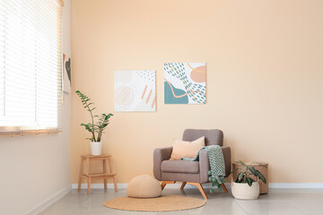 Interior of living room with stylish paintings, armchair and plants