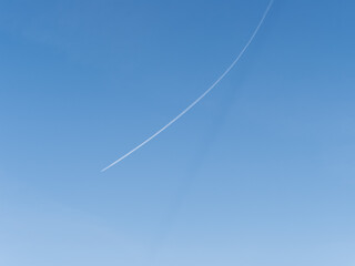 Blue sky with airplane trails and clouds.
