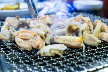 roasting pieces of raw eels on a charcoal grill in a Korean restaurant