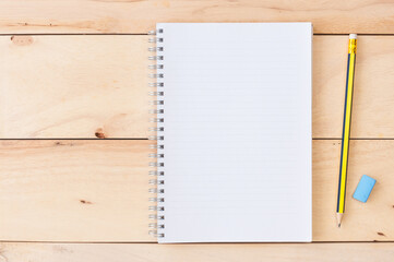 Blank notebook with pencil & eraser on wooden background