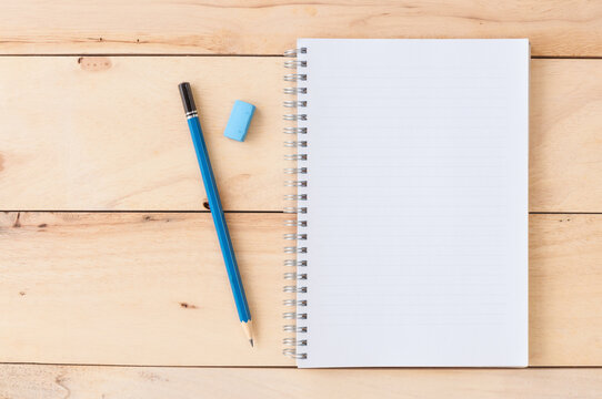 Blank notebook with pencil & eraser on wooden background - Powered by Adobe